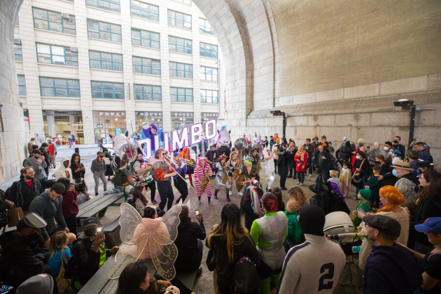 A crowd in costume gathers under the Archway for the Dumboween party