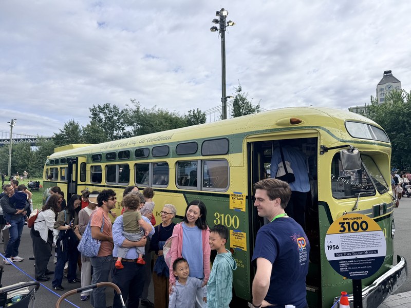 Families line up to board vintage Bus 3100 at the New York Transit Museum Bus Festival in Brooklyn Bridge Park
