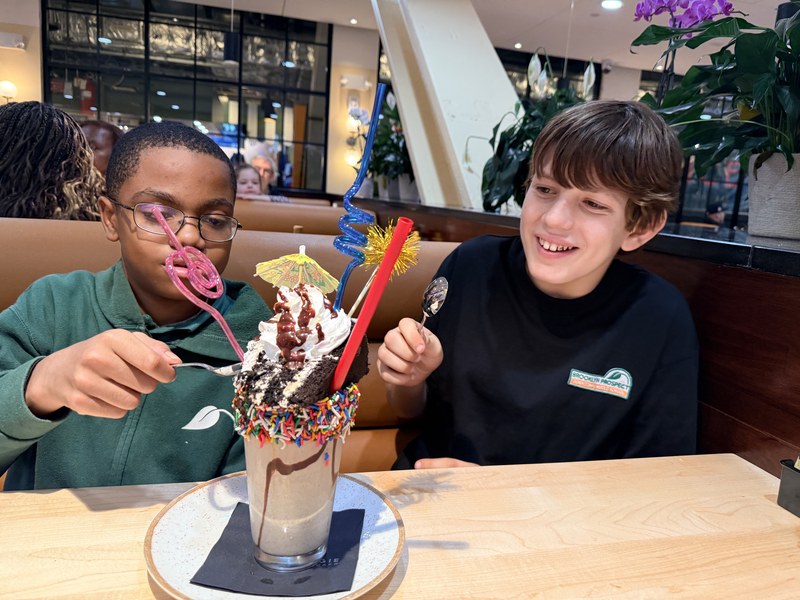 Two kids sharing an oversized decorated milkshake at Carnegie Diner & Cafe in Downtown Brooklyn
