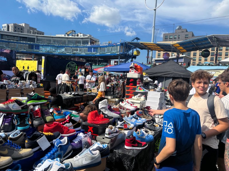 Two tweens browsing tables of sneakers at Sneaker Con in Coney Island