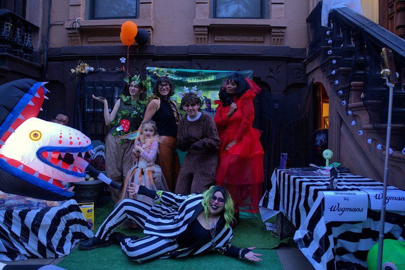 A Bed-Stuy brownstone stoop decorated for Halloween with neighbors in costume
