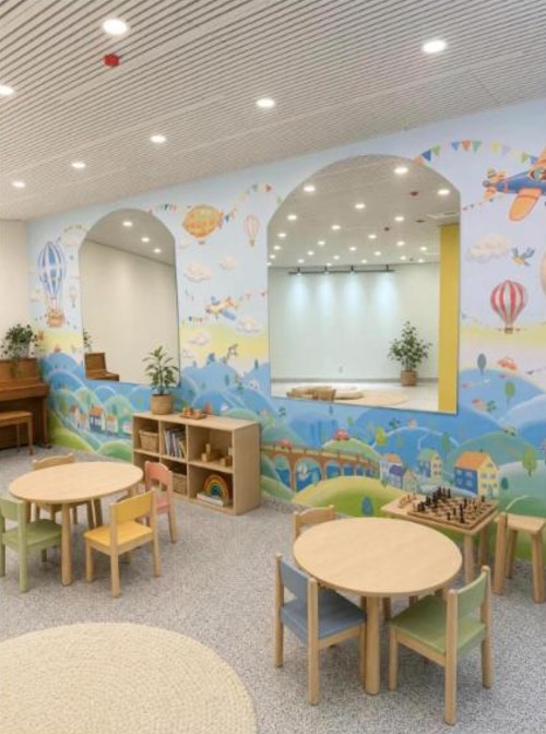 Classroom with a hot-air-balloon mural, small wooden tables and chairs at Gifted and Talented Kids in Greenpoint