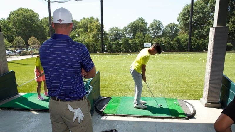 A young golfer lines up a shot on a green at City Parks Foundation’s Junior Golf Center in Brooklyn