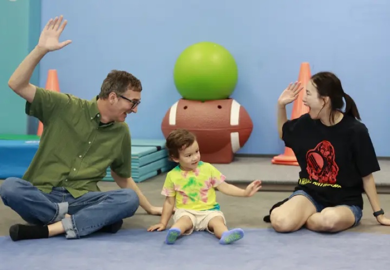 A parent, a teacher and a toddler during a class at a My Gym children’s fitness center