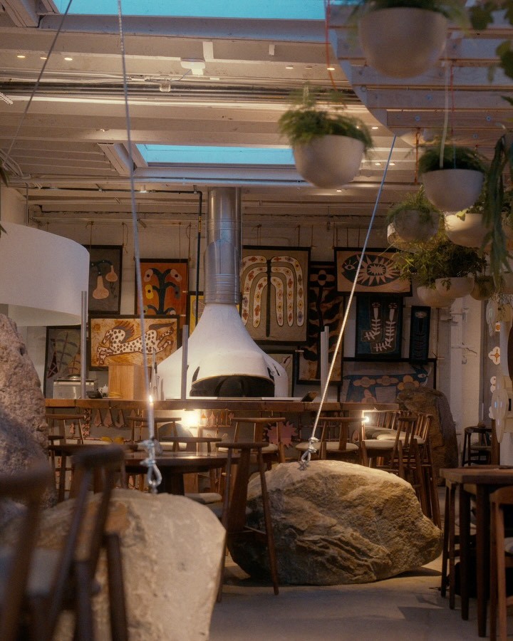The dining room at Pizza 4P’s in Greenpoint, with a wood-fired oven, hanging plants, skylights and large boulders between the tables
