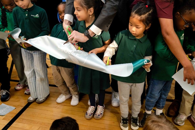 Kindergartners in green uniforms cut the ribbon at the opening of Prospect Schools’ Windsor Terrace campus